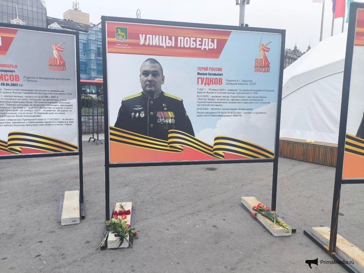 Цветы у плаката с Героем России Михаилом Гудковым. Олег Кожемяко стал крестным дочери Героя